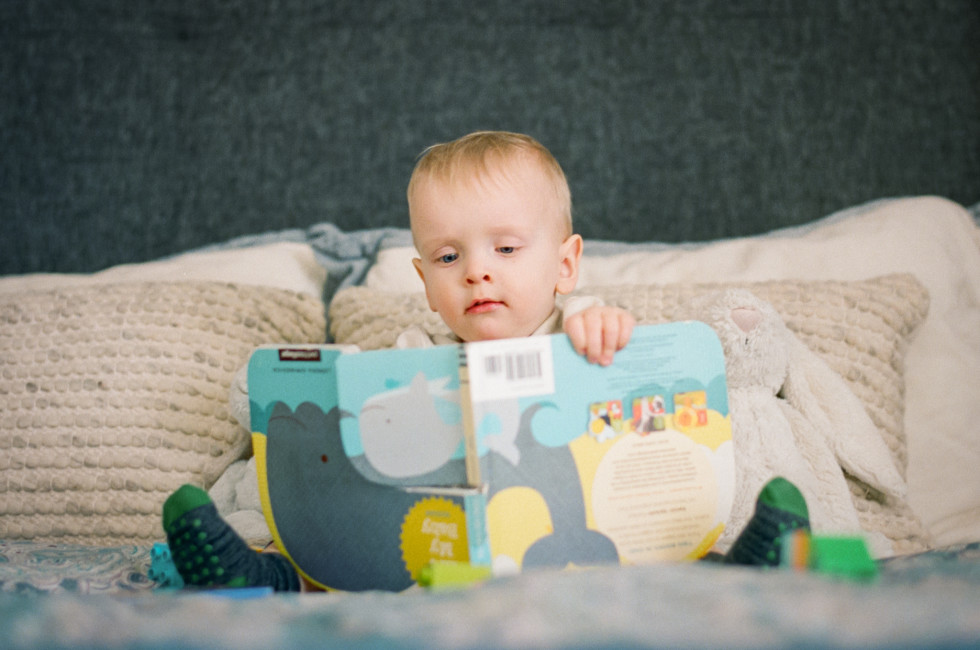 toddler reading an upside-down book