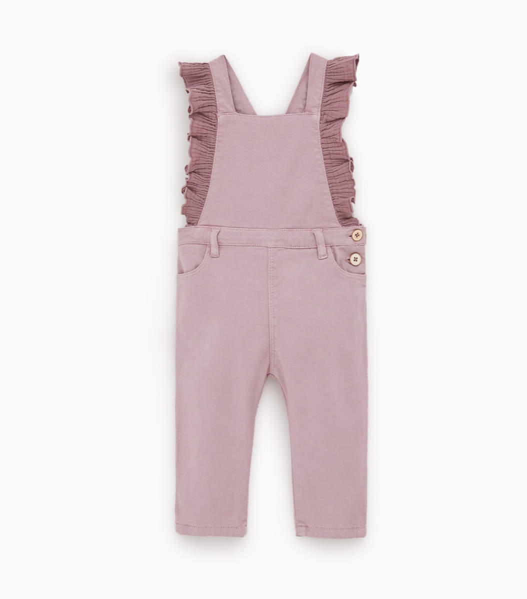 Mauve overalls with a ruffle on the sleeve in a toddler girl size. Set on a plain white background